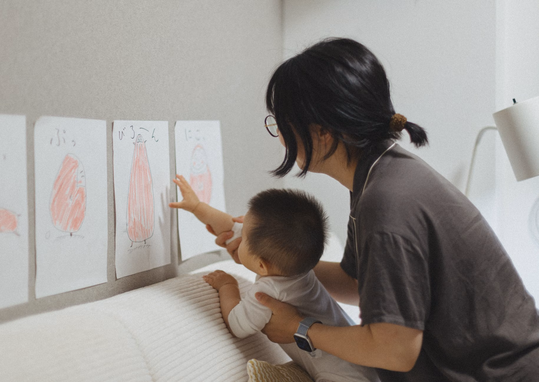 아이의 창의성을 키우는 거실 '미니 갤러리', 실패 없이 꾸미는 7가지 방법 2 아이의 그림을 벽면 갤러리 시스템에 직접 거는 모습