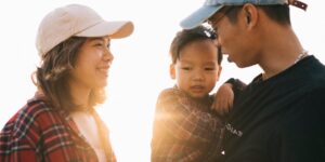 따뜻한 햇살 아래 아이와 눈을 맞추며 대화하는 부모의 모습