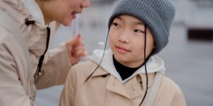 아이와 눈을 맞추며 대화하는 따뜻한 분위기의 부모와 아이