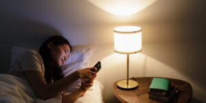 심야 시간에 작동하는 스마트 가전과 에너지 절약 앱을 보여주는 아늑한 거실 풍경