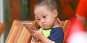 스마트폰을 활용해 아이의 언어 발달을 기록하는 부모와 아이의 모습