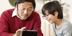 30대 아빠와 아이가 태블릿으로 반도체 투자와 성장 그래프를 함께 보고 있는 따뜻한 거실 풍경