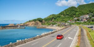 푸른 바다를 배경으로 달리는 오키나와 렌터카 여행의 풍경